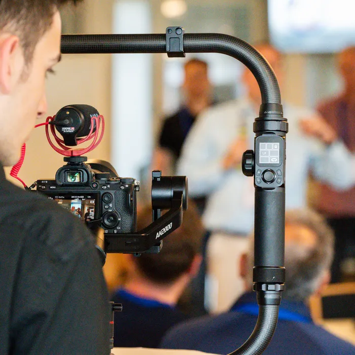 A videographer filming a session with a gimbal-mounted camera