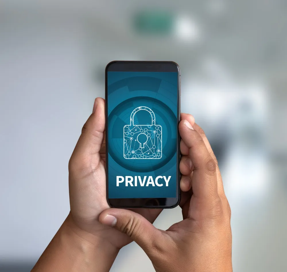 Hands holding a smartphone showing a padlock and the word PRIVACY
