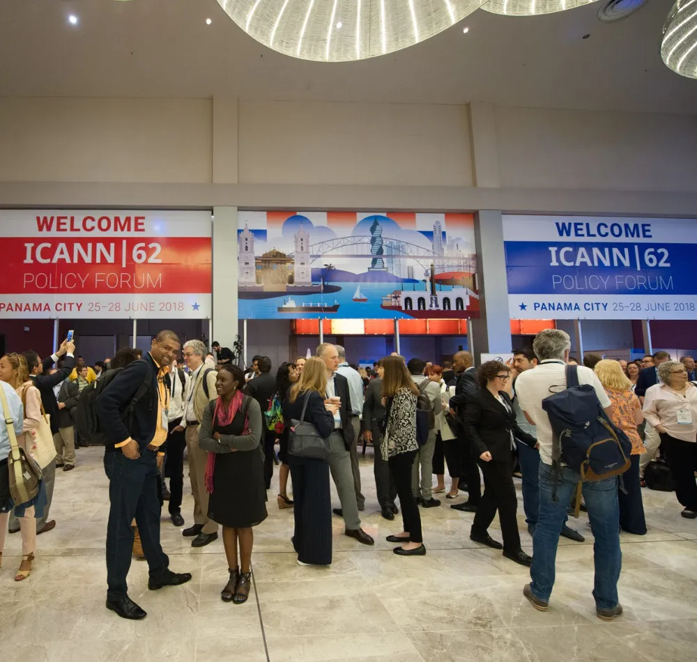 Attendees gathered in front of ICANN 62 Policy Forum welcome banners