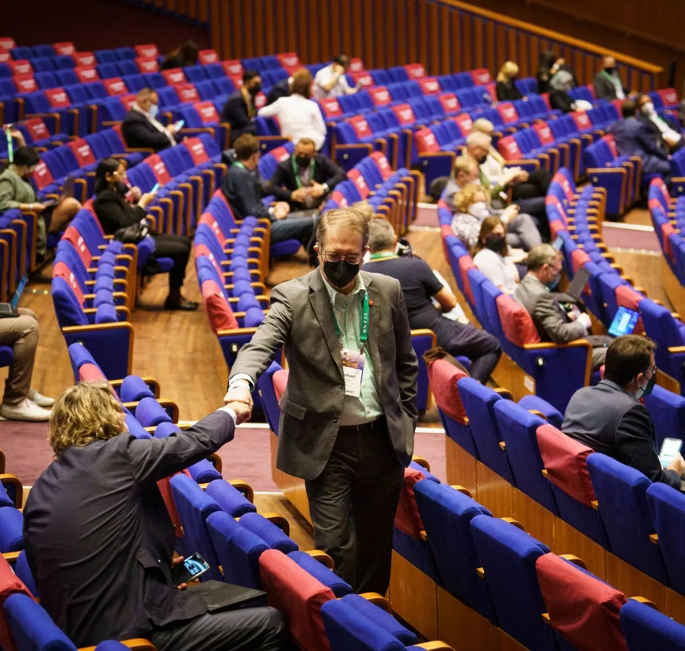 Attendees shaking hands in the aisles of a conference auditorium