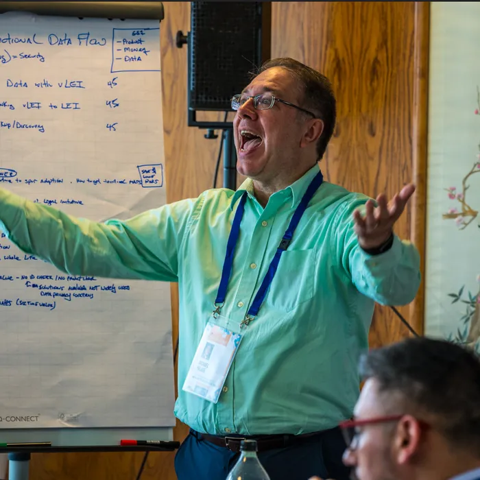 A team member presenting in front of a flip chart sketch of an omni-directional data flow