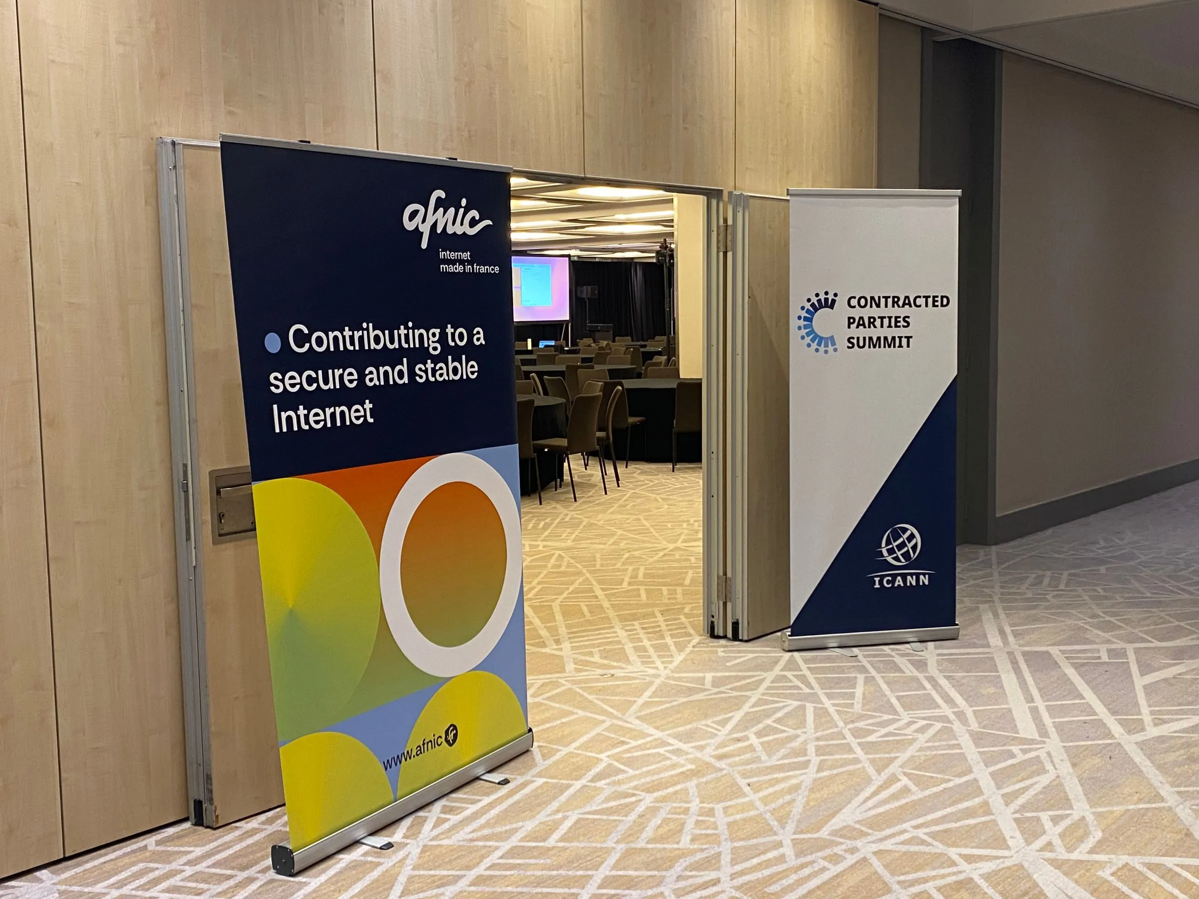 Afnic and ICANN Contracted Parties Summit banners at the entrance to a meeting room